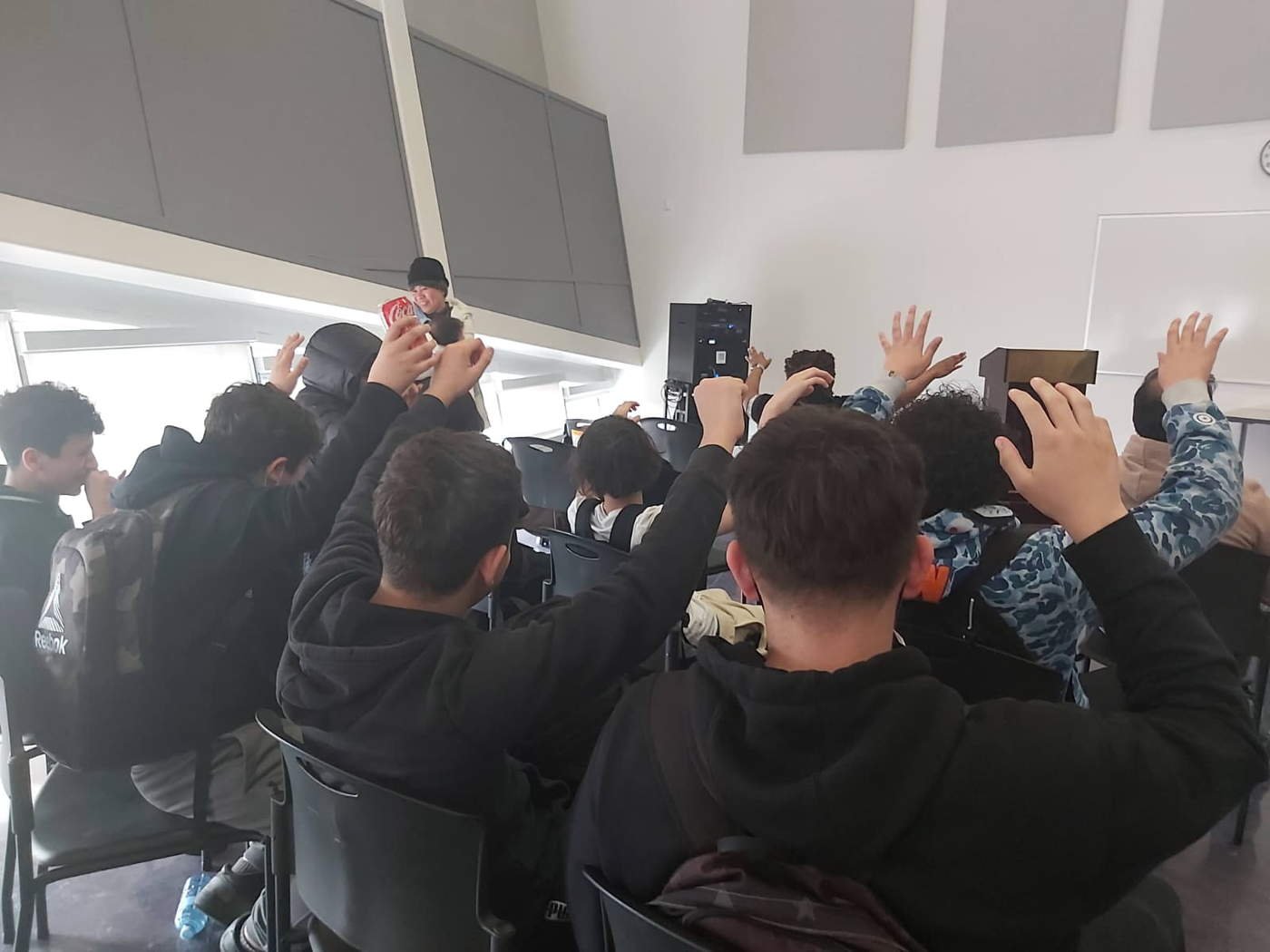 Youth with hands raised in worship from behind